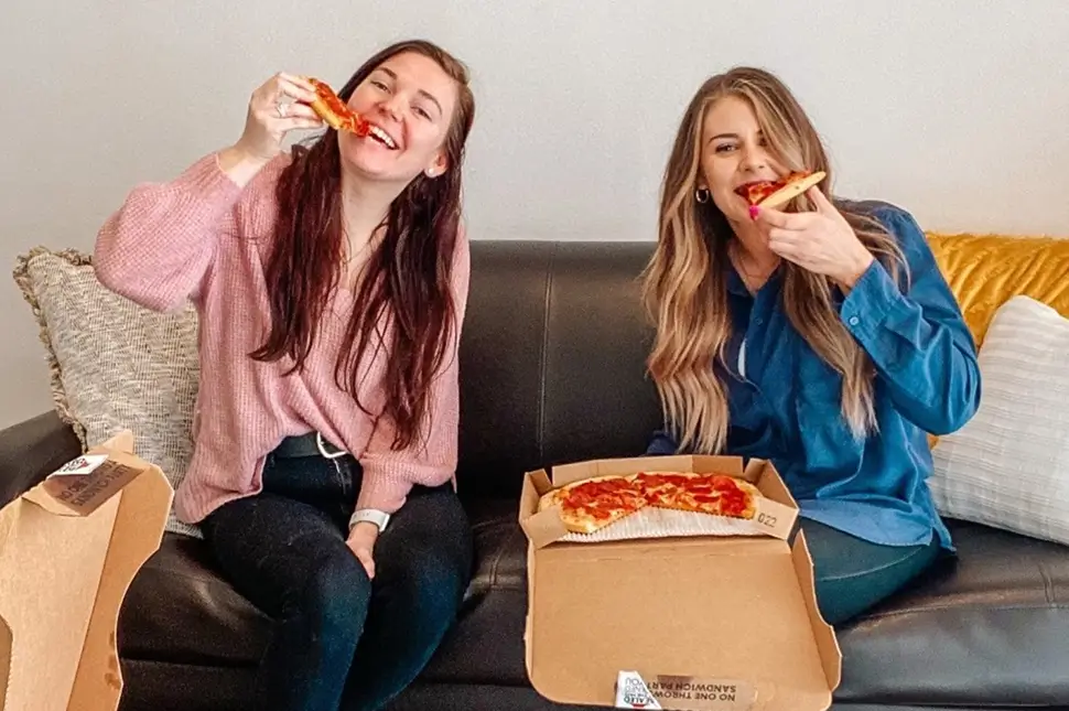 young women eating pizza